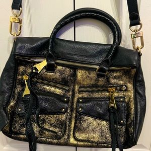 Aimee Kestenberg black leather bag with gold metallic accents and pulls
